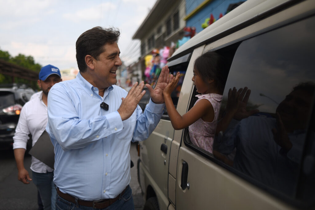 Carlos Pineda, ex candidato presidencia de Guatemala, choca la mano a una niña en una actividad.