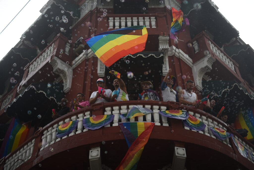 Personas muestran bandera gay desde edificio de la zona 1 de Ciudad de Guatemala en el Pride 2022.