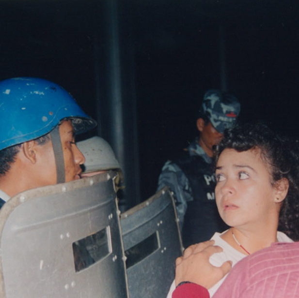 Un manifestante mira a la policía antidisturbios durante protestas en contra del proyecto Babilonia. Daniel Graham