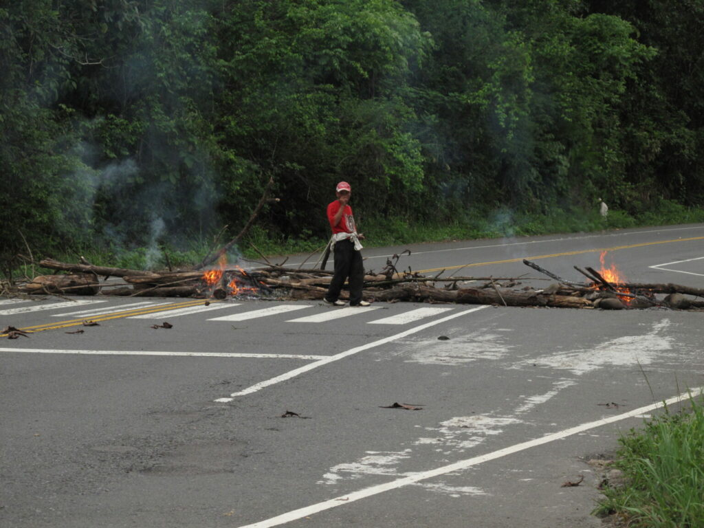 Un manifestante se para frente a los restos de un bloqueo de carretera tras una protesta en contra de la represa Barro Blanco.
