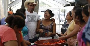 Tres Kiebres rodeado de mujeres que preparan la comida para su celebración como alcalde electo. Foto: Eduardo González